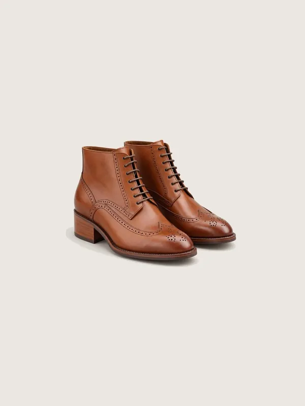 AI-generated product photo of the cognac wingtip brogue boots, one of the pieces in the Someone Shop.